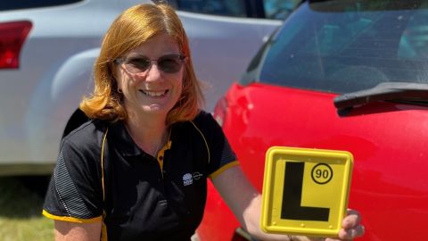 Kate McDougall holding an L plate.