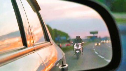 Motorbike seen through car side mirror