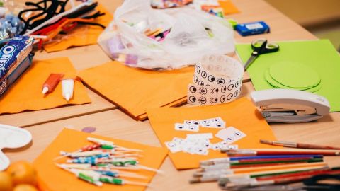 Craft items to make badges, spread out on a table.