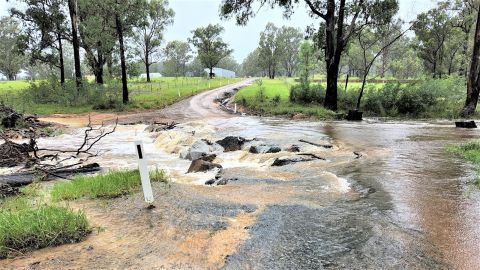 Causeway on country road in flood and breaking up