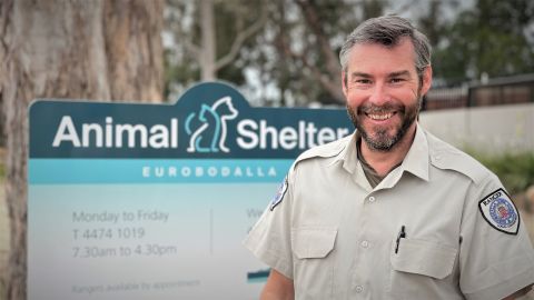 Man standing in front of sign for animal shelter