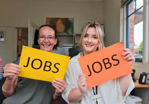 2 ladies holding signs that say Jobs.
