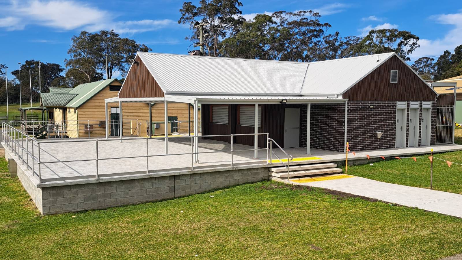 Image Brick building with covered concrete patio and toilet facilities.