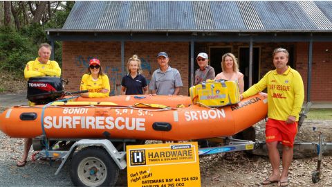 a group of people standing behind an inflatable rescue boat 