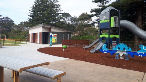 Playground in foreground with toilet block behind it