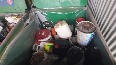 buckets of chemicals in a metal waste bin