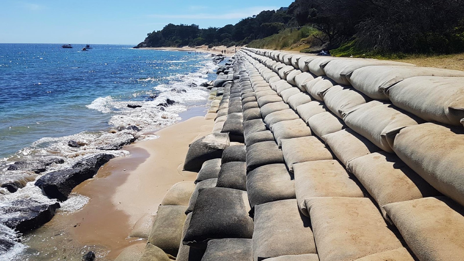 Image Long rows of sandbags along the shoreline form steps..