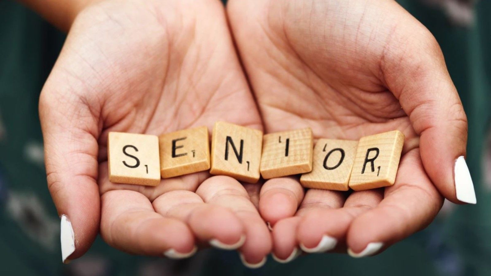 Hands holding scrabble letters spelling senior banner image