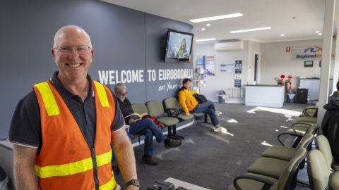 Man smiling inside an airport terminal 