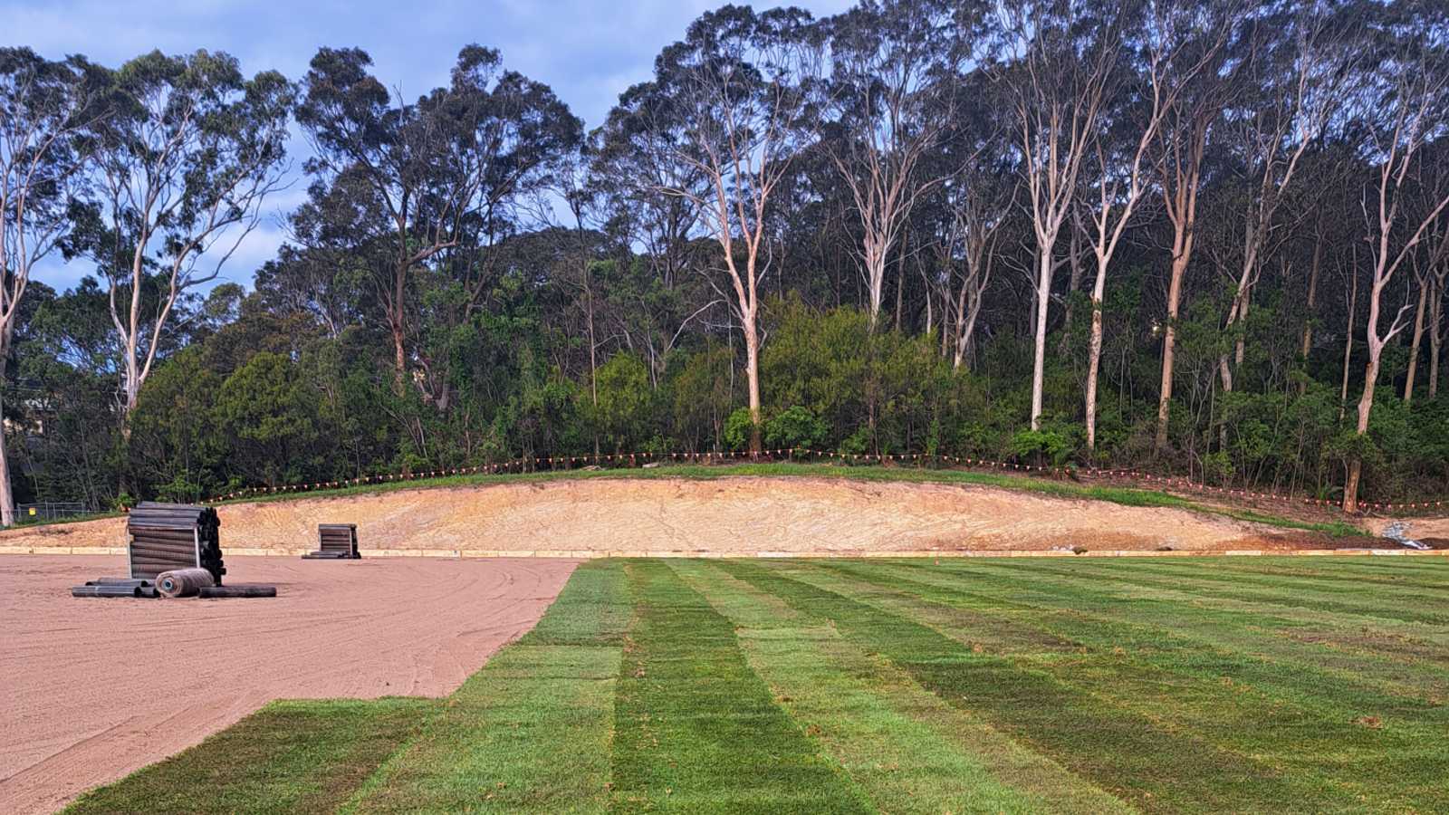 Image Instant turf is being rolled out over a flat field 